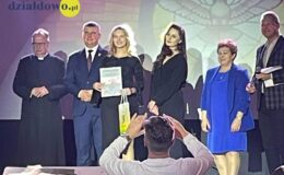 na scenie stoi grupa osób, kobiety i mężczyźni